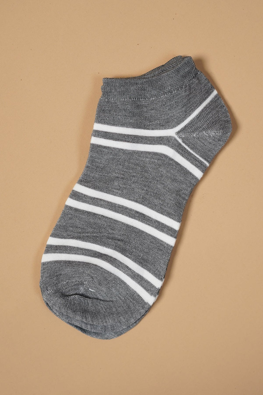 Gray ankle sock with white stripes on a light brown background.