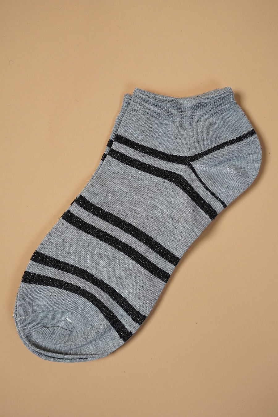 Gray ankle sock with black stripes on a beige background.